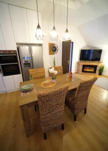 Tekla apartman في غيولا: مطبخ وغرفة طعام مع طاولة وكراسي خشبية
