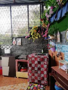 a kitchen with a stove and some flowers on a wall at Love homestay CT in Kangar