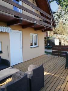 una terraza de madera con una puerta blanca en una casa en Chata Hulina 