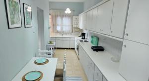 kuchnia z białymi szafkami i zielonymi akcentami w obiekcie Garden House Katerini w mieście Kateríni