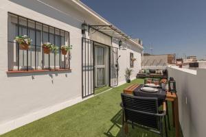 małe patio ze stołem i krzesłami na balkonie w obiekcie Avanti Alameda Sky Terrace, DISFRUTALO w Sewilli