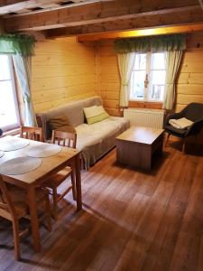 a living room with a couch and tables and windows at U Toma in Malá Morávka