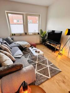 ein Wohnzimmer mit einem Sofa und einem TV in der Unterkunft Schönes 3-Zimmer-Apartment in Bremen-Findorff Nähe HBF, Zentrum, Messegelände in Bremen