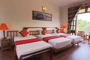 a bedroom with two beds with red and white sheets at Windbell Villa Hoi An in Hoi An