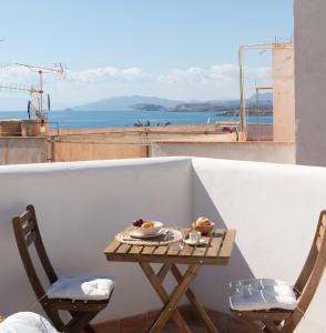 una mesa y sillas en un balcón con vistas al océano en La Casa Turquesa en Águilas