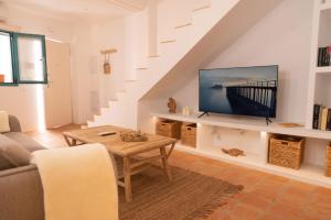 a living room with a couch and a tv at La Casa Turquesa in Águilas