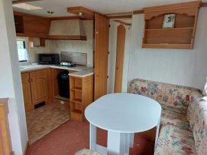 a small kitchen with a white table in a tiny house at Braemar Equestrian, East Riding of Yorkshire in Burton Pidsea
