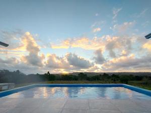 a swimming pool with a sunset in the background at Finca Jasmat in Cabrera