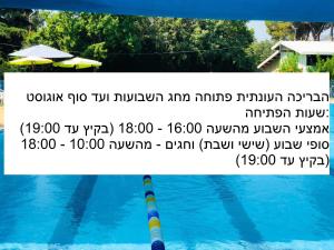 a sign on the side of a swimming pool at Erettz Dafna Travel Hotel in Metsudat Menahem Ussishkin Alef