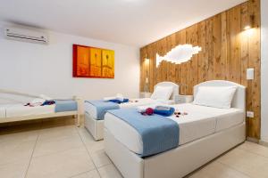 a room with two beds and two chairs in it at Crystal Villa III in Chrissi Akti +40 photos