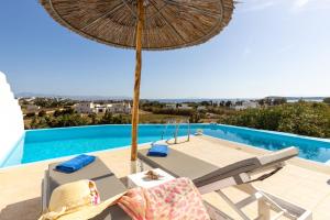 a patio with an umbrella and chairs and a swimming pool at Crystal Villa III in Chrissi Akti