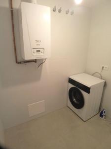 - Lavadora y secadora en una habitación pequeña en AMIZADE APARTAMENTO, en Pontevedra