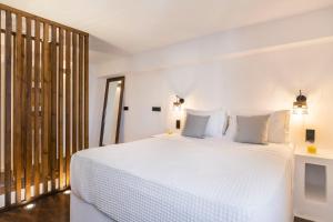 een slaapkamer met een groot wit bed met witte kussens bij Afluencia Complex Studio No1 in Naousa