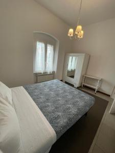 ein Schlafzimmer mit einem großen weißen Bett und einem Spiegel in der Unterkunft Trainspot Apartment in La Spezia