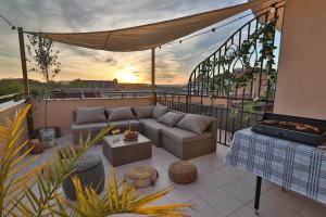 a patio with a couch and a table on a balcony at Messembria Resort in Sunny Beach