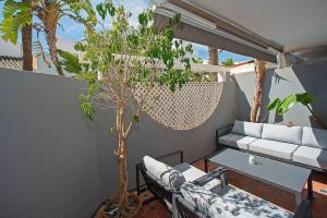 a living room with a couch and a tree at Beautiful and Quiet Family Townhouse in Great Location in Marbella