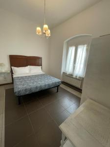 Schlafzimmer mit einem Bett und einem Kronleuchter in der Unterkunft Trainspot Apartment in La Spezia
