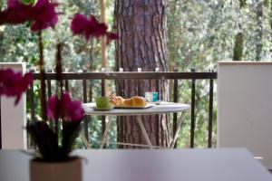 un tavolo con una tazza di caffè e un piatto di pane di Villa Antonietta 3, tra pineta e mare a Bibione