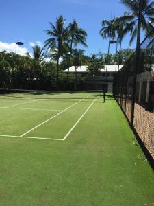 a person is playing tennis on a tennis court at Nimrod Resort Apartments in Port Douglas