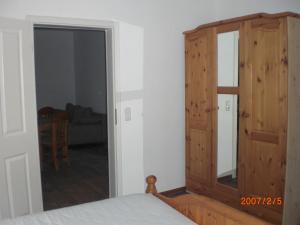 a bedroom with a wooden door and a mirror at gramelower see in Teschendorf