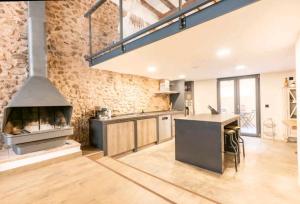 a large kitchen with a brick wall and an oven at Tu refugio in Montbrió del Camp