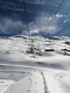 een skilift op een met sneeuw bedekte berg met sneeuw bedekte grond bij Appartement Valmeinier 4 à 5 personnes Résidence LAGRANGE in Valmeinier