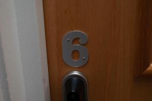 a number on a wooden door with a metal number six at higgihaus #5 Room 6 Monday - Friday in Cardiff