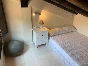 Un dormitorio con una cama y una lámpara en una mesita de noche. en La Casa de los Molineros, en Albarracín