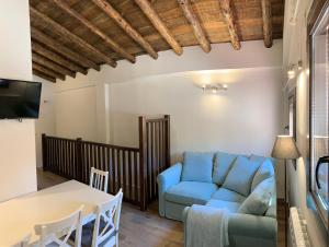 Una sala de estar con un sofá azul y una mesa. en La Casa de los Molineros, en Albarracín