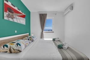 a bedroom with a large bed with a window at Newly renovated apartment with a beautiful sea view Emili in Promajna