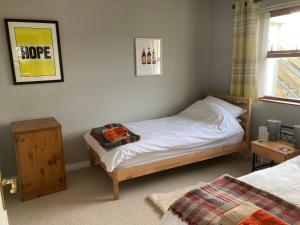 um pequeno quarto com uma cama e uma janela em Milo's Cosy Cottage Giant's Causeway em Bushmills