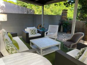 d'une terrasse avec des canapés, des chaises et une table. dans l'établissement La kaze manguiers, à L'Étang-Salé