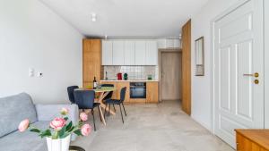 a living room and kitchen with a table and chairs at Apartamenty PIAMOLA Bursztynowe Osiedle Jantar in Jantar