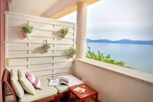 einen Balkon mit einer Bank und Blick auf das Wasser in der Unterkunft Holiday Home Labineca in Gradac