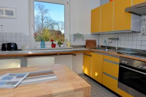 una cucina con armadi gialli e tavolo in legno di Haus Memel a Niendorf