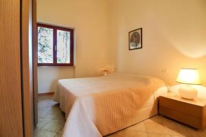 a bedroom with a bed and a table with a lamp at Casa Procchio in Procchio