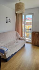 a living room with a couch and a large window at Messembria Resort in Sunny Beach