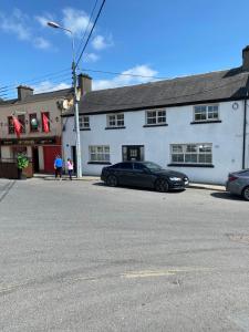 a black car parked in front of a white building at Rooms At Mcternans in Kilcullen