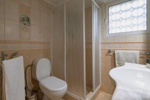 a bathroom with a toilet and a sink and a window at Eternal Summer Time Villa for 6 in Dhaskalión +33 photos