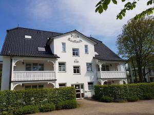 un edificio bianco con tetto nero di Villa Seefisch, Wohnung 4 mit Terrasse a Göhren