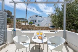 einen Balkon mit zwei Stühlen und einem Tisch mit Essen drauf in der Unterkunft Hotel Manto in Naoussa