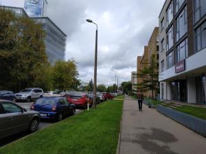 a person walking down a street with parked cars at Vesetas NON-smoking One Bedroom Apartments in Rīga