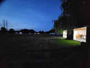 eine Gruppe Bänke, die im Gras in der Nähe eines Gebäudes sitzen in der Unterkunft Dorset Glamping Fields in Corfe Mullen