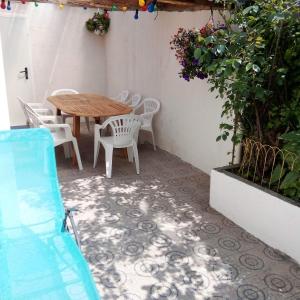 a patio with a wooden table and white chairs at L'APPARTEMENT BOULONNAIS in Boulogne-sur-Mer