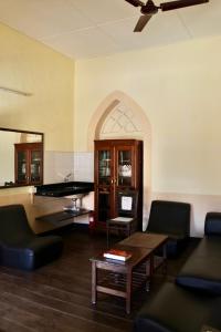 a living room with a table and a piano at Royal Phoenix Inn in Panaji