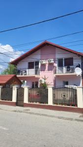 蘇利納的住宿－Casa Laur，粉红色和白色的房子,有黑色的围栏