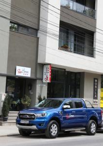 een blauwe truck geparkeerd voor een gebouw bij ResHome in Focşani