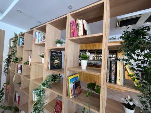 a wooden book shelf with books and plants at Apartamentos Rio by Garvetur in Vilamoura