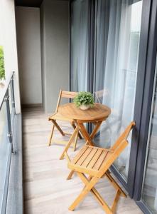 einen Holztisch und einen Stuhl auf dem Balkon in der Unterkunft ResHome in Focşani
