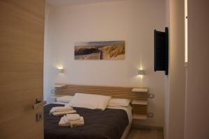 um quarto com uma cama com toalhas em Villa Antonietta 1, giardino privato, mare e pineta em Bibione